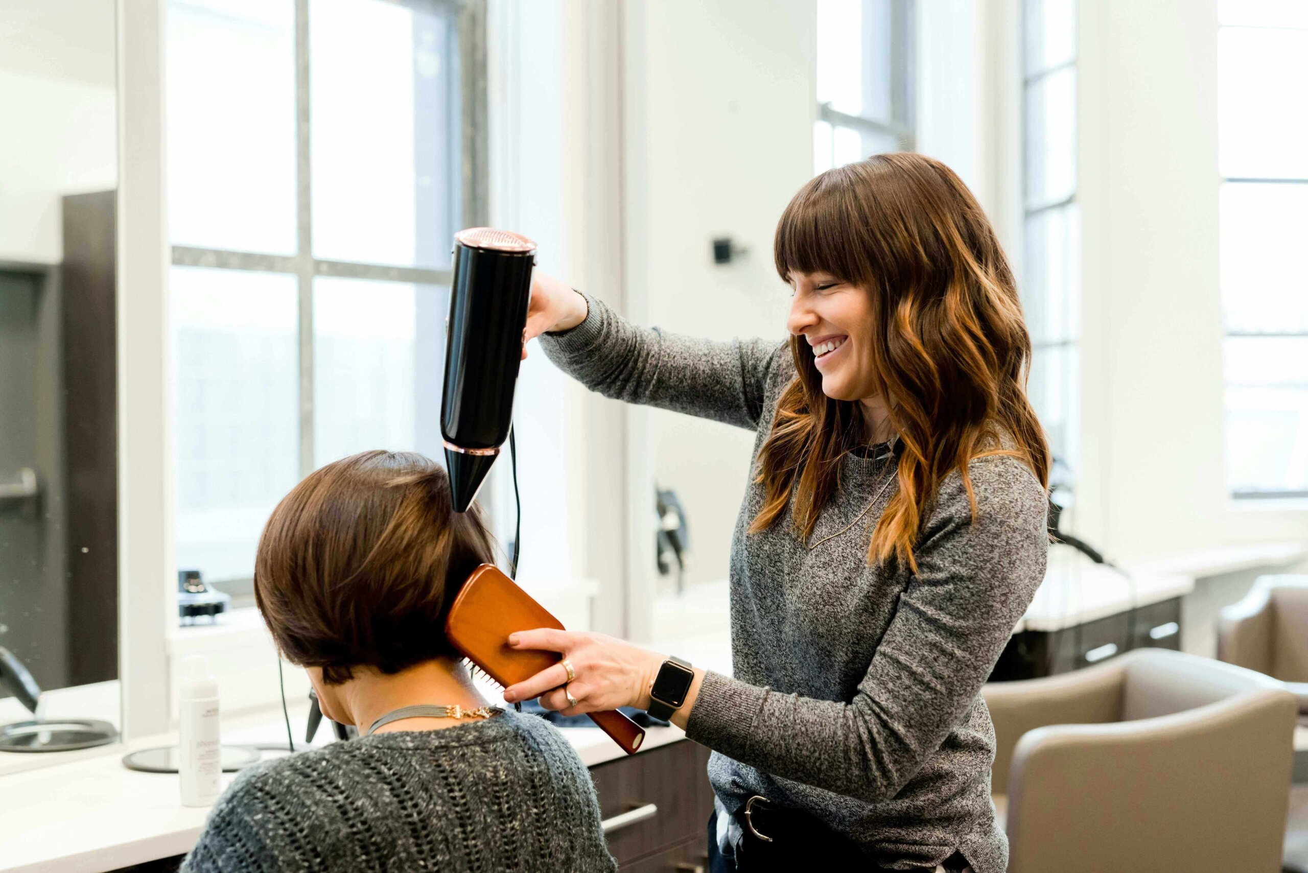 Image of hairdresser blowdrying customers hair.
