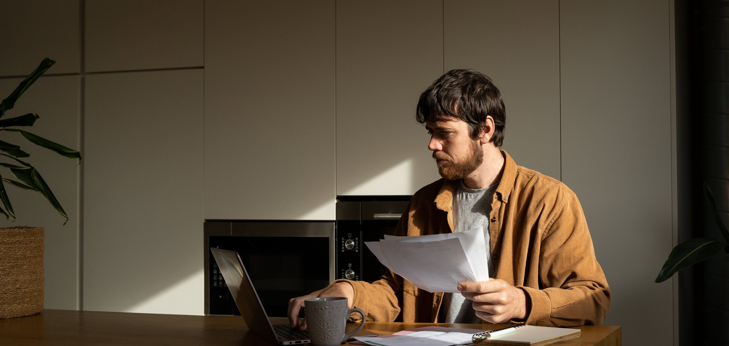 Man holding two Director Penalty Notices (DPNs) looking for advice online.