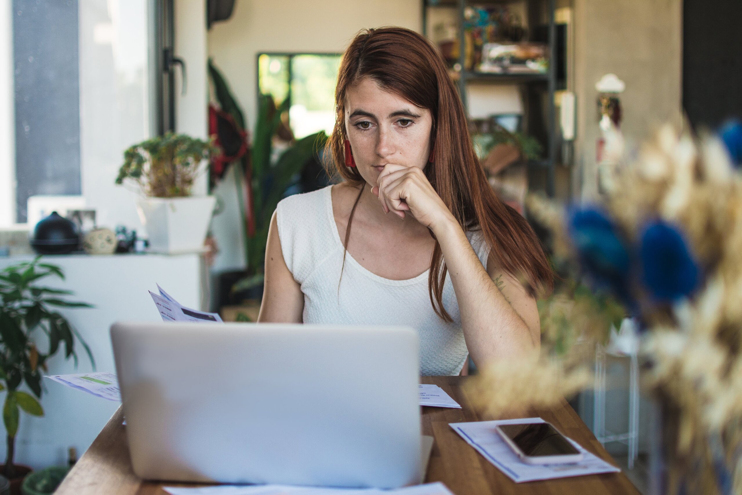 Small business owner reviewing financial documents at home, trying to diagnose financial issues in their business.