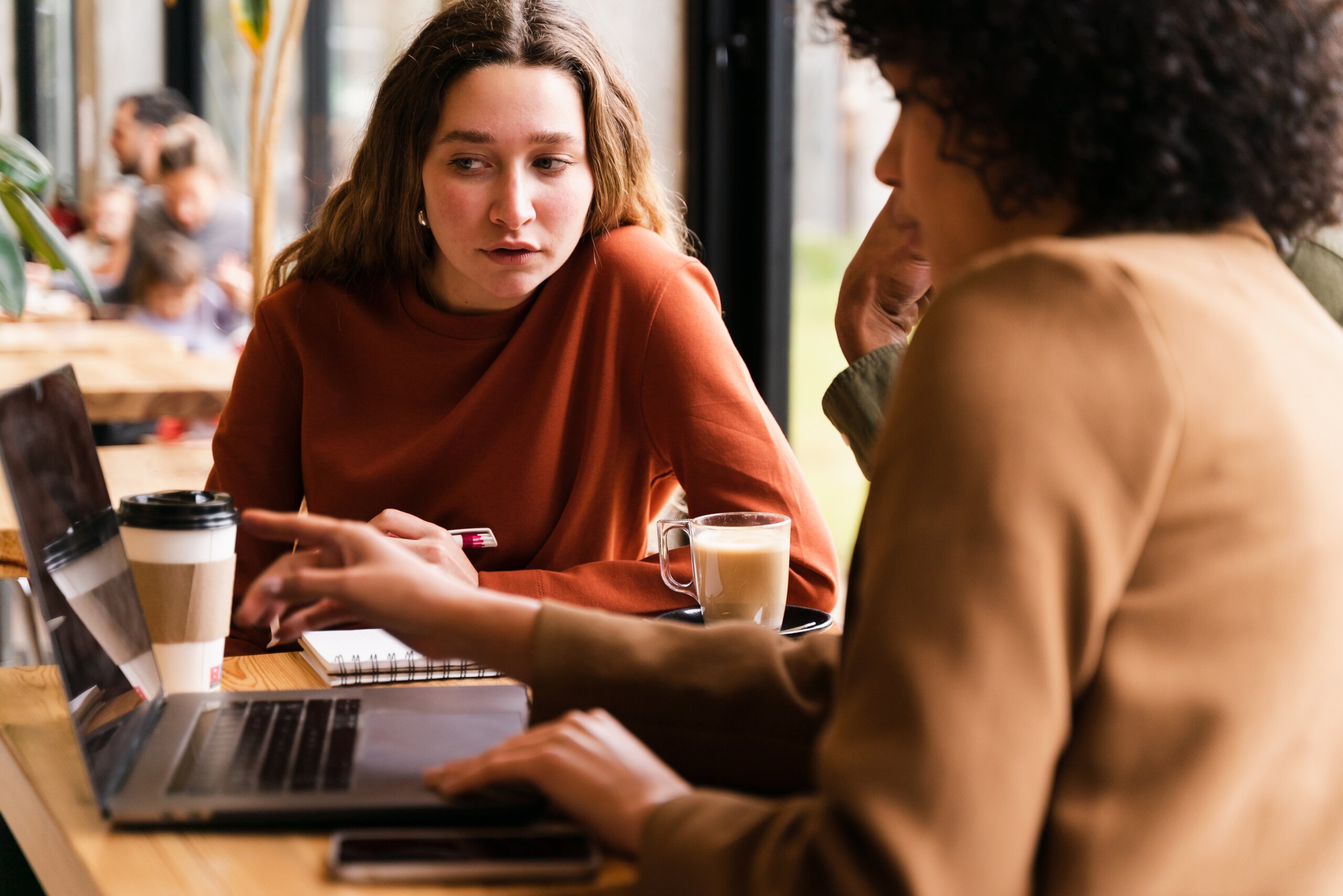Women looking at laptop in discussion.